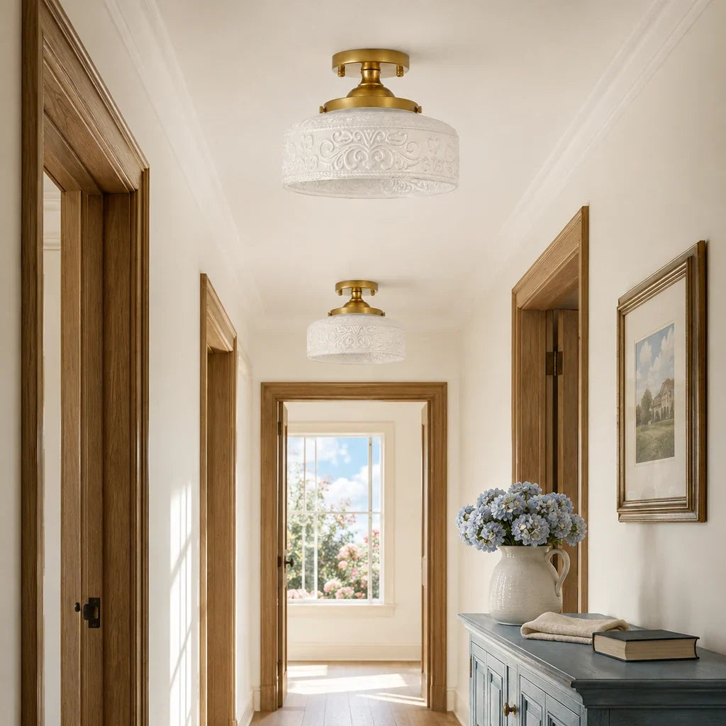 Pair of gold and white embossed glass ceiling lights in a bright upstairs hallway